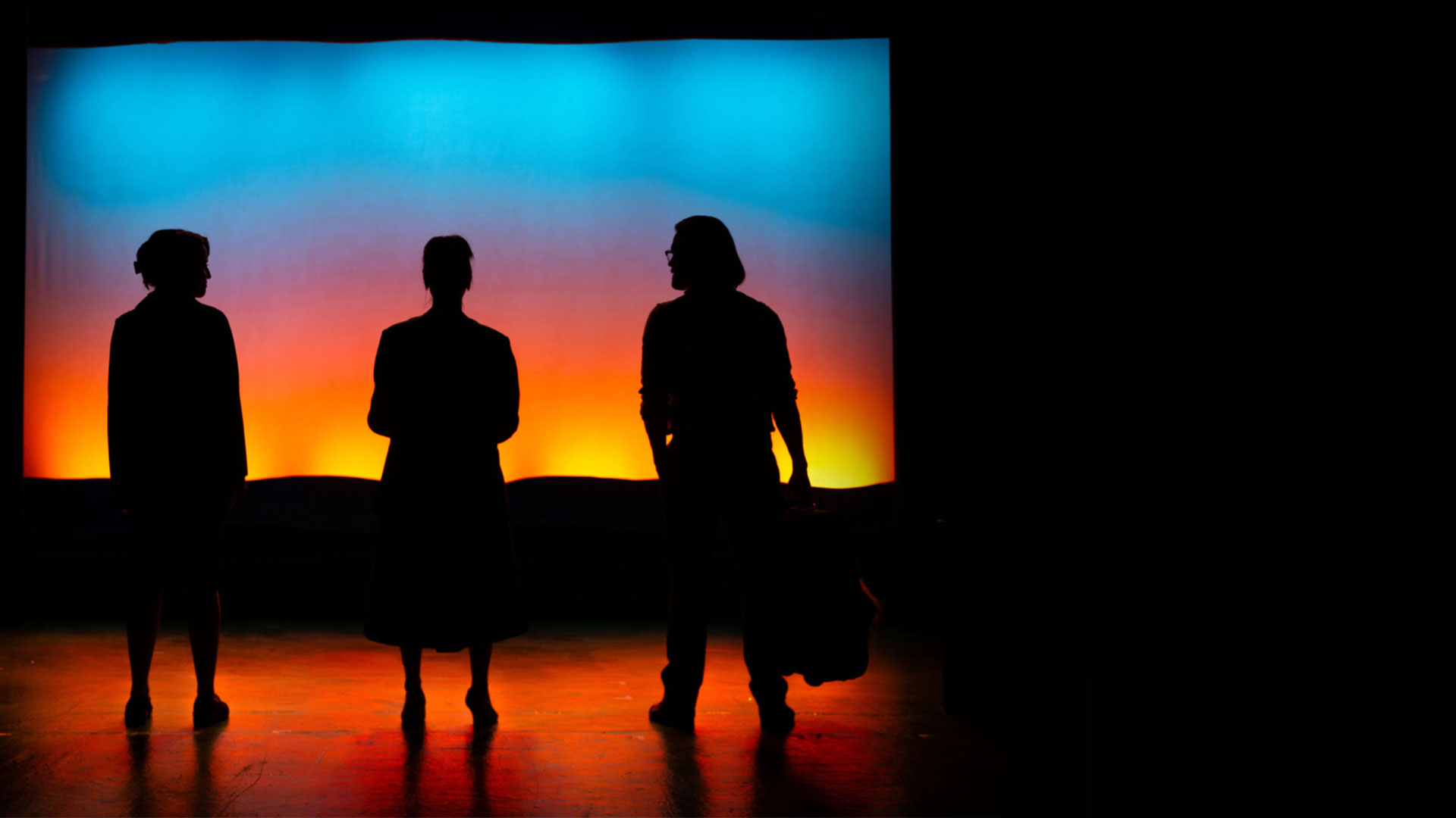 Three silhouettes against a gradient backdrop that resembles a sunset